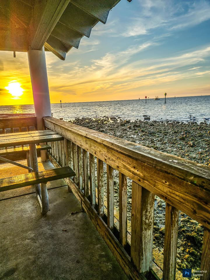 Sunset over the water from a wooden pier